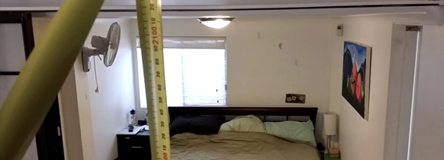Measuring the ceiling height of a bedroom with a tape measure